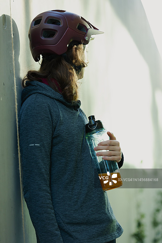疲惫的运动员女孩在骑自行车后休息图片素材