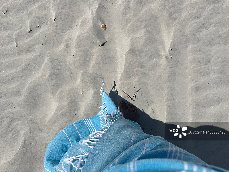 裹着土耳其浴巾在沙滩上行走的女人图片素材