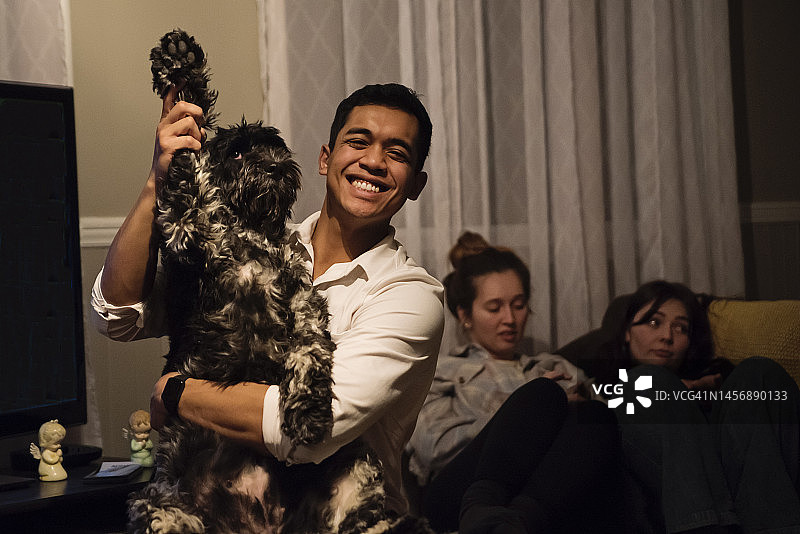 和狗一起参加家庭聚会的年轻人图片素材