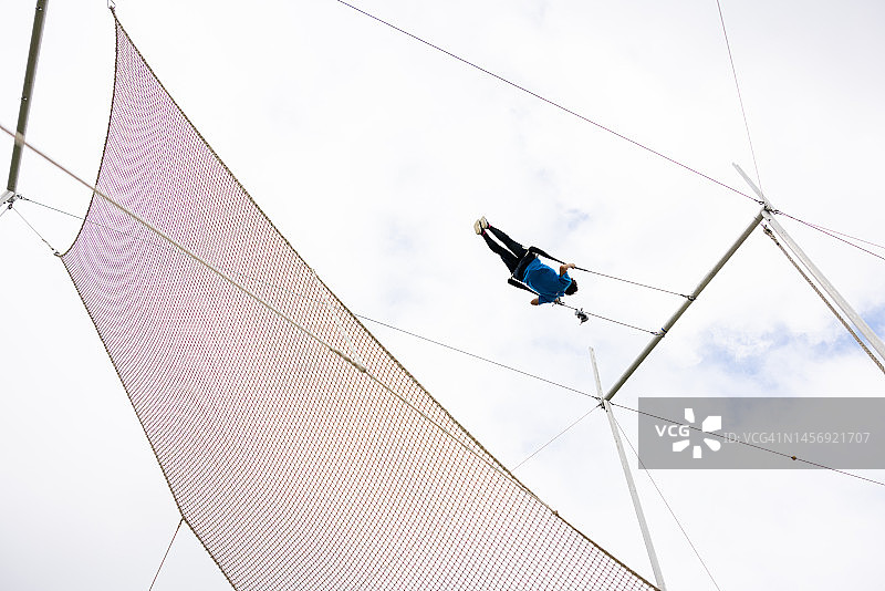 年轻女空中飞人演员在空中摇摆图片素材