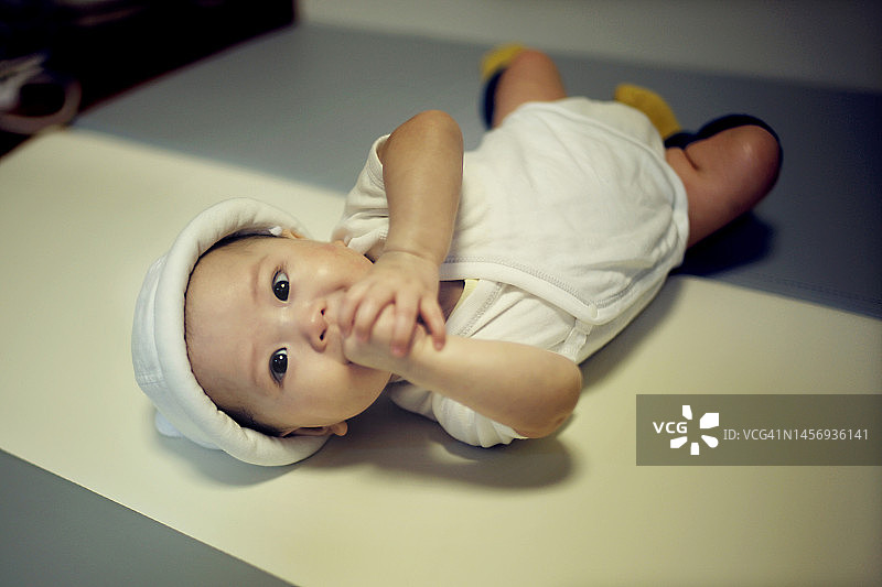 捂住嘴巴的亚洲女婴肖像图片素材