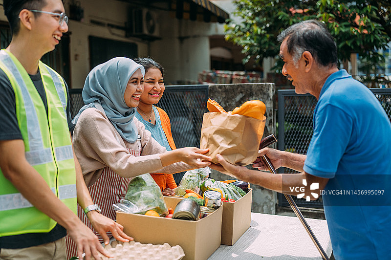 微笑女志愿者在社区分发食物图片素材
