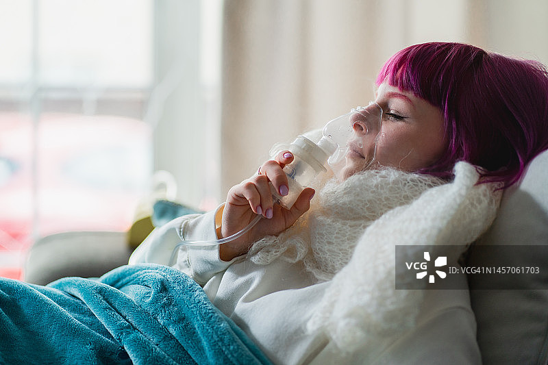使用雾化器进行哮喘医疗：女性在家中吸入药物图片素材