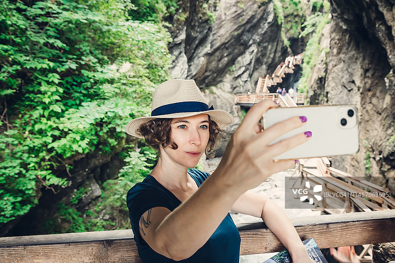 女人在户外用智能手机自拍图片素材