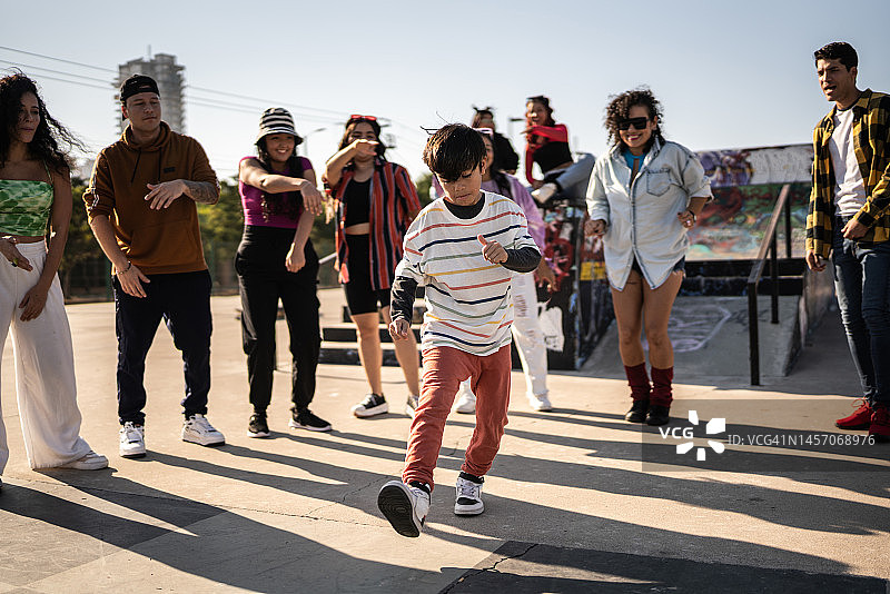 男孩在户外街头派对上和朋友们一起跳霹雳舞图片素材