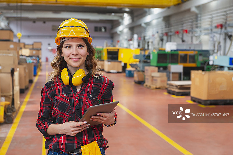 微笑年轻女工使用平板电脑的肖像图片素材