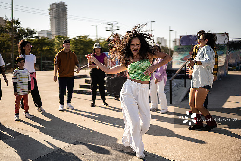 中年妇女在户外街头派对上和朋友一起跳雷鬼舞的肖像图片素材