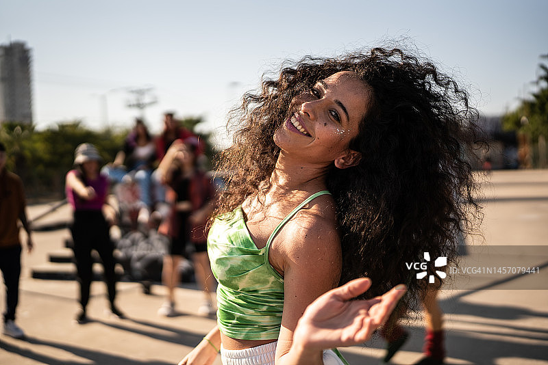 中年妇女在户外街头派对上和朋友一起跳雷鬼舞的肖像图片素材