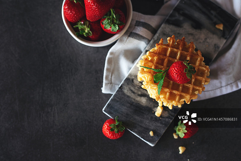 灰色背景上可爱的小华夫饼。甜点。上菜。甜蜜美味的食物。图片素材