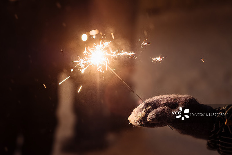 夜晚街上手持的焰火特写图片素材