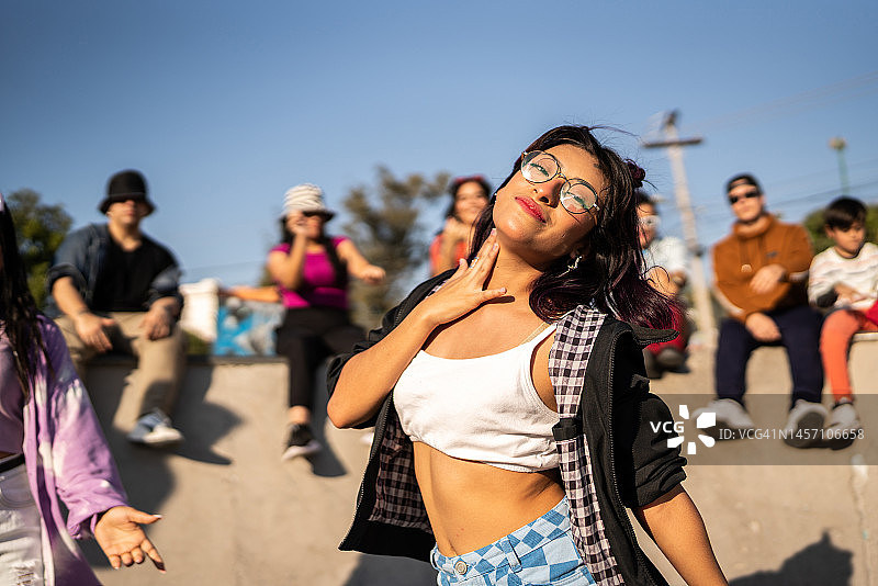 在街头派对上跳嘻哈舞的年轻女人肖像图片素材