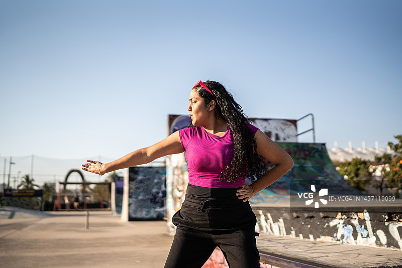在滑板公园跳雷鬼舞的年轻女人图片素材