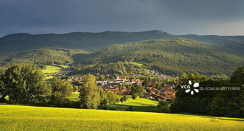德国巴伐利亚拉姆小镇及其周边景观，夏季雷雨后乌云与阳光交织图片素材