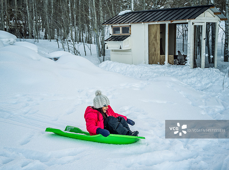 年轻女孩的雪橇滑雪乐趣图片素材