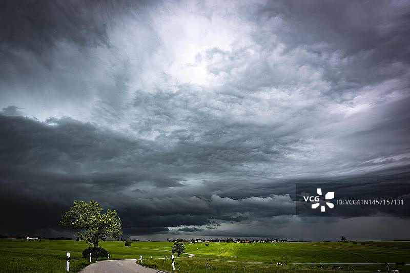 道路与草地，背景是雷雨天空，德国巴伐利亚图片素材