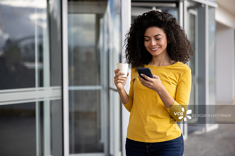 快乐的商务女性在咖啡休息时间查看手机图片素材