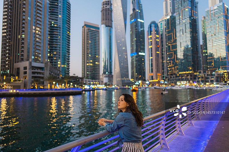 日落时分在迪拜码头散步的女人图片素材