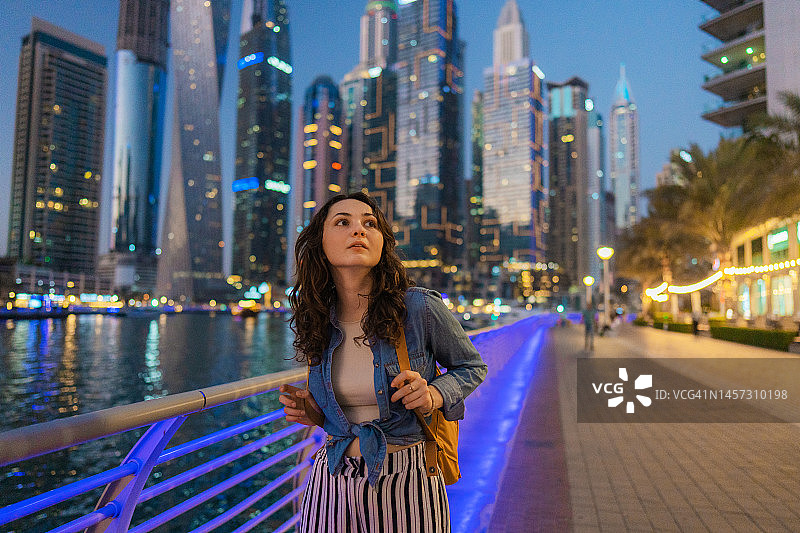 日落时分在迪拜码头散步的女人图片素材