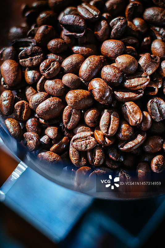 在家用咖啡研磨机中新鲜烘焙的咖啡豆图片素材