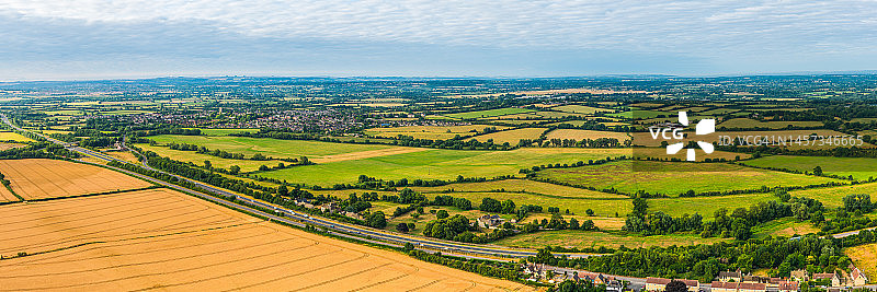 农田、绿色牧场、村庄和高速公路的鸟瞰全景图片素材
