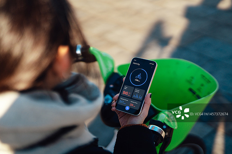 使用健身追踪App监测自行车通勤的年轻亚洲女性图片素材