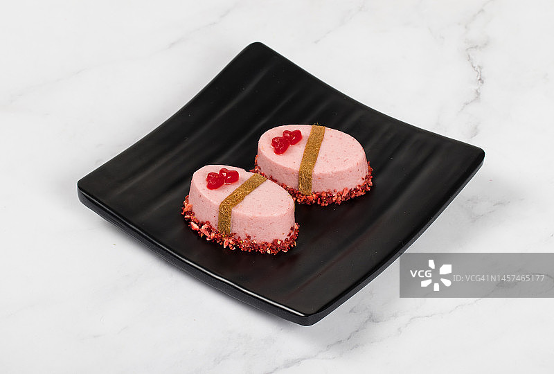 草莓慕斯甜点，用冻干草莓和红色心形果冻装饰，白色背景，情人节图片素材