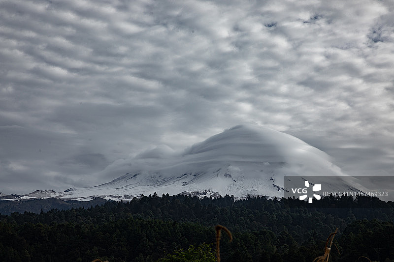 清晨多云天空下的波波卡特佩特雪火山图片素材