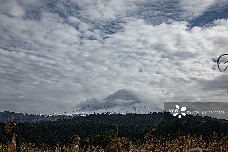 清晨多云天空下的波波卡特佩特雪火山图片素材