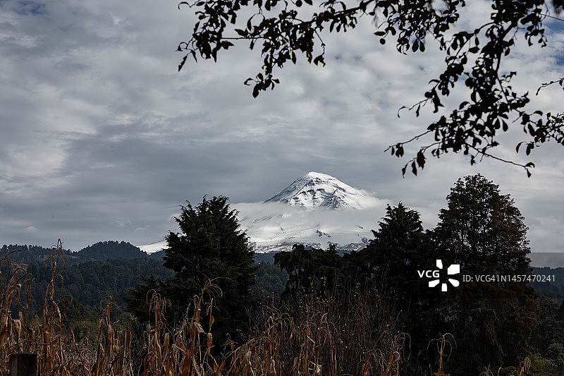 阴天寒冷时节眺望被白雪覆盖的波波卡特佩特火山图片素材
