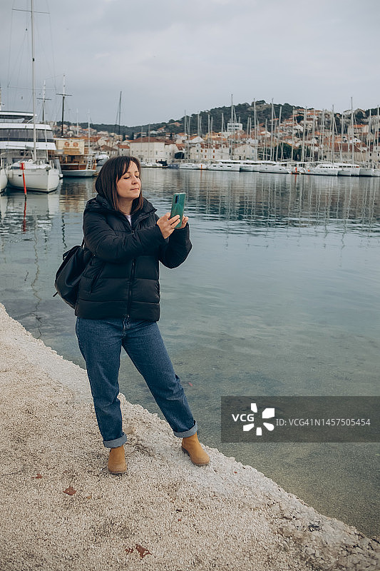 一名女子在海港堤岸上自拍图片素材