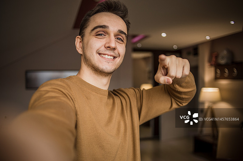 英俊的白人男子在客厅里自拍图片素材