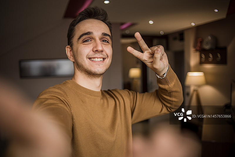 英俊的白人男子在客厅里自拍图片素材