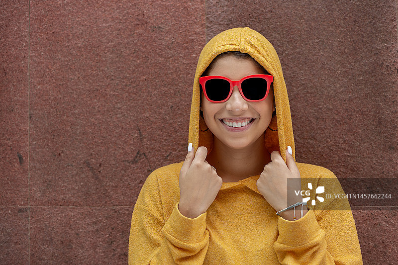 身穿黄色连帽衫的快乐年轻女子图片素材