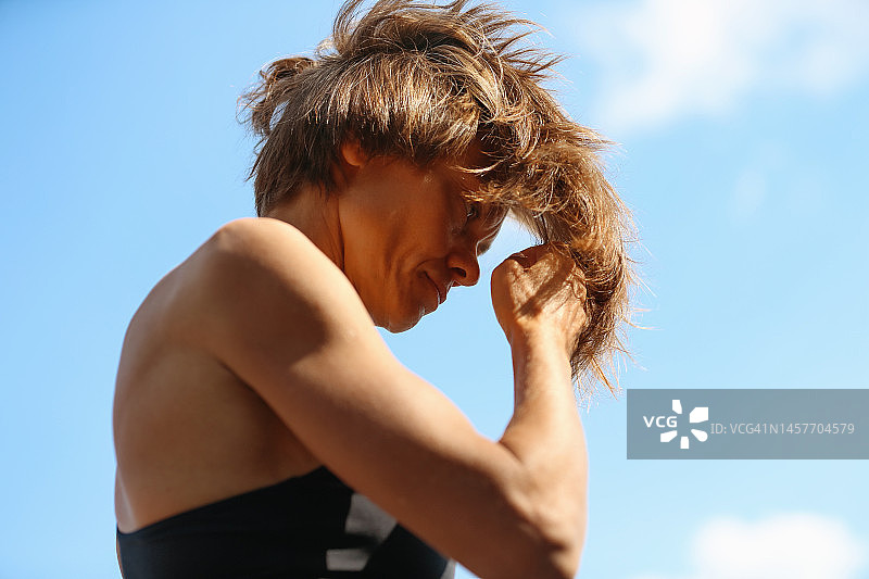 蓝天下冲浪的成年女性侧面照图片素材