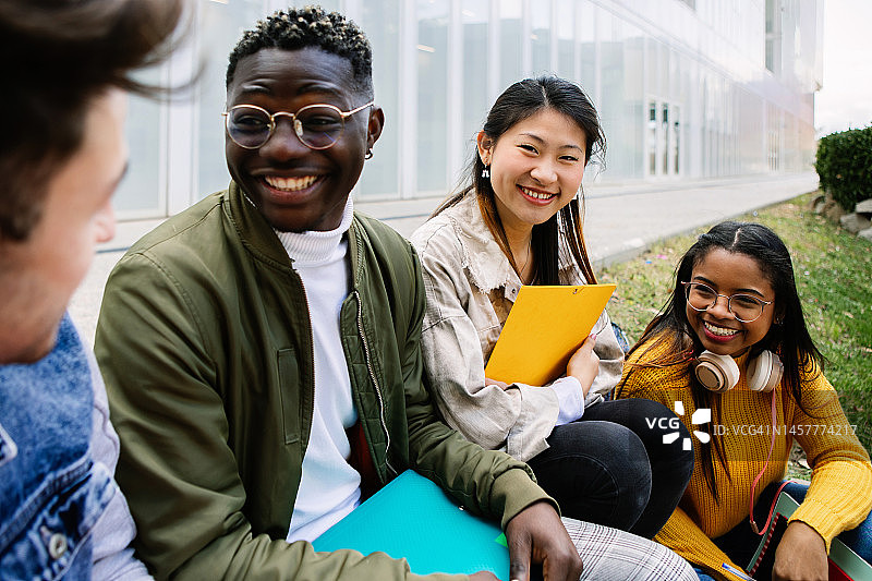 多民族的年轻学生朋友在大学校园里闲逛 - 亚洲少女对着镜头微笑 - 国际伊拉斯谟交流项目概念图片素材