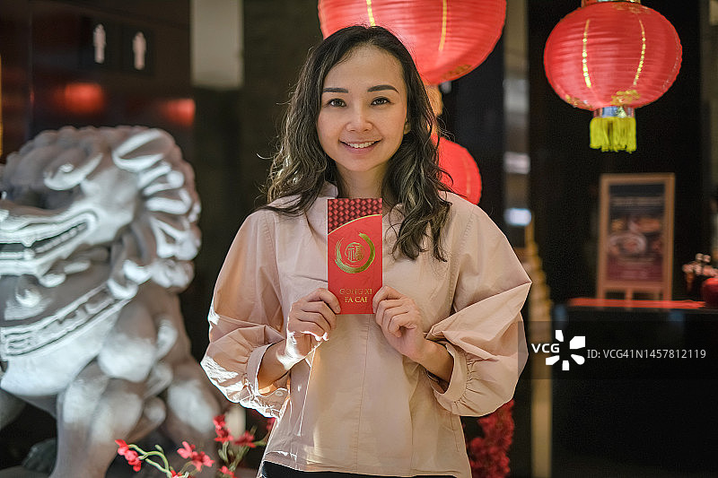 微笑的中国女人拿着红包图片素材