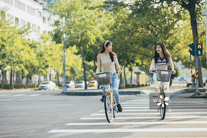 两位亚洲女性租自行车在城市里旅行图片素材