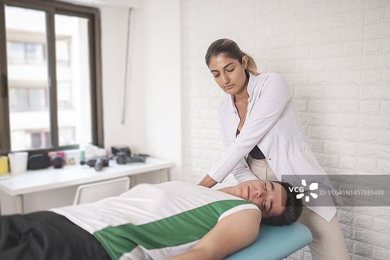女理疗师正在检查她的病人图片素材