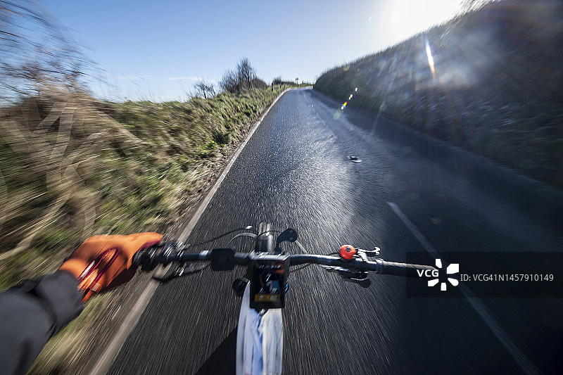 自行车手在柏油路上骑行的主观视角图片素材