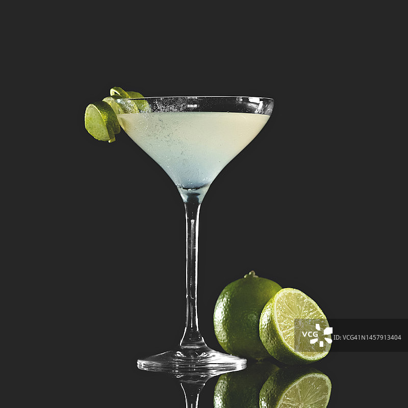 玛格丽特鸡尾酒：龙舌兰酒、酸橙汁和柑橘利口酒，用酸橙装饰的鸡尾酒杯，在反光桌子上，深色背景，带复制空间图片素材