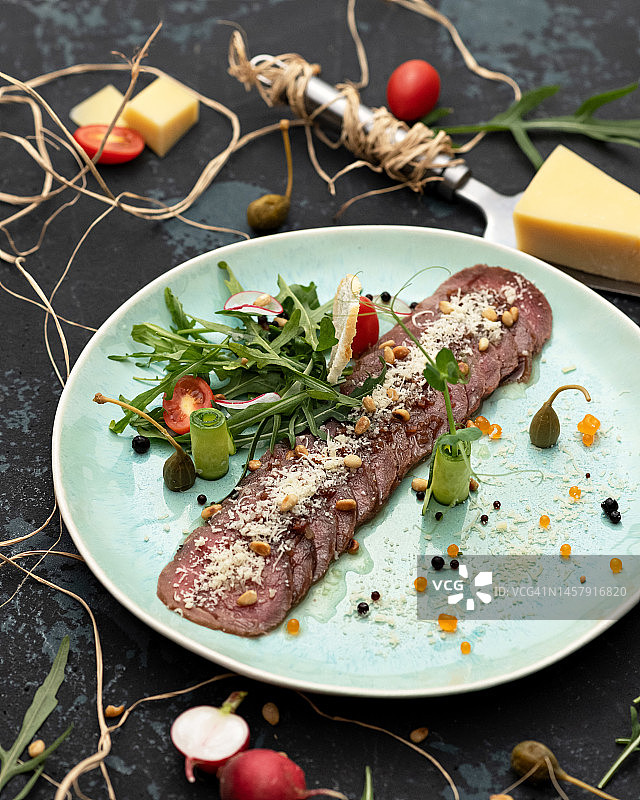 烤肉片配蔬菜和帕尔马干酪，深色背景图片素材