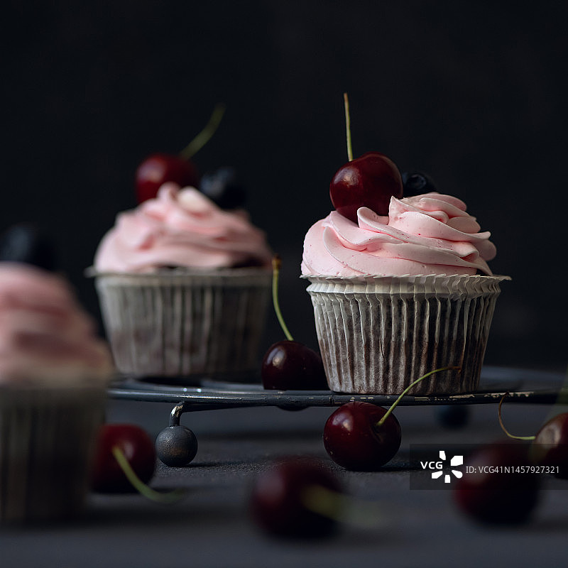 金属架上的奶油樱桃巧克力杯子蛋糕图片素材