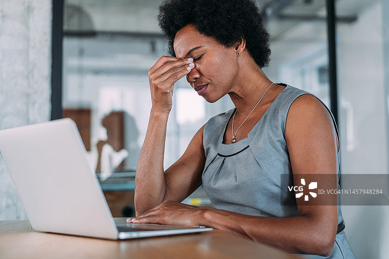 办公室里过度劳累的年轻女商人图片素材