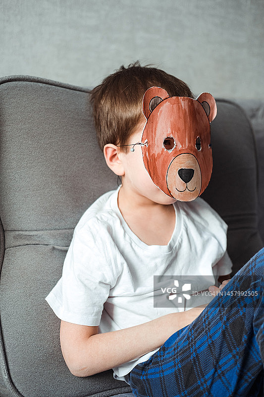 男孩制作了一个纸熊面具并戴上，DIY纸工艺图片素材