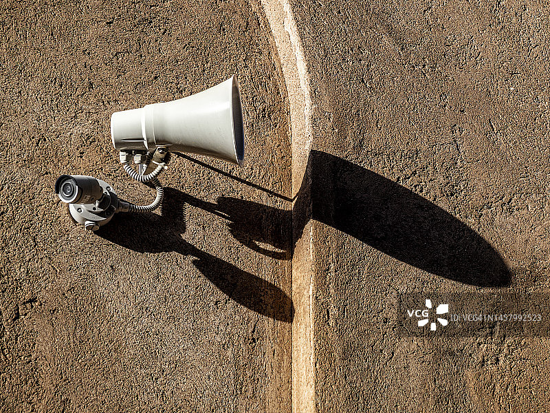 建筑物墙上的安全监控摄像头和紧急警报器图片素材