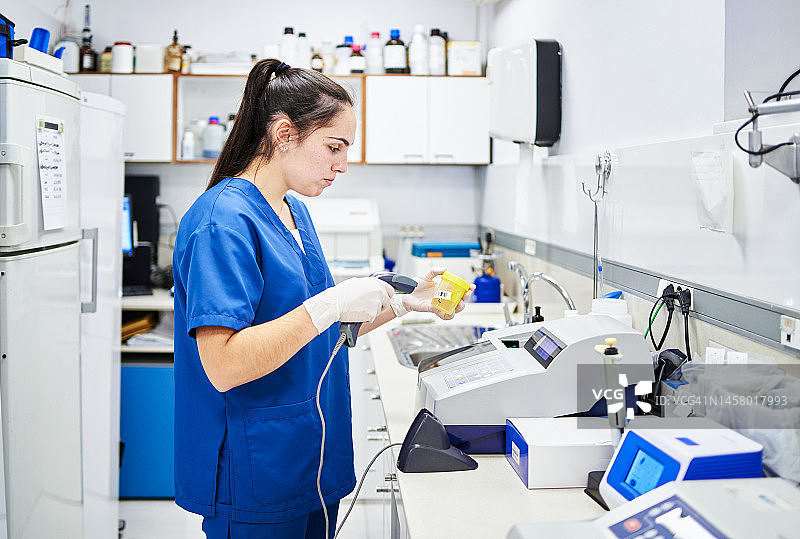 工人在分析实验室扫描样品罐图片素材