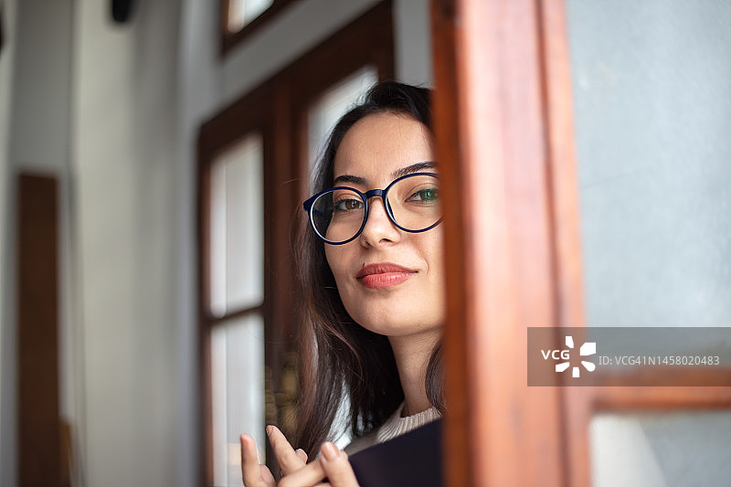 在公共图书馆里手捧书本的美丽年轻女人图片素材