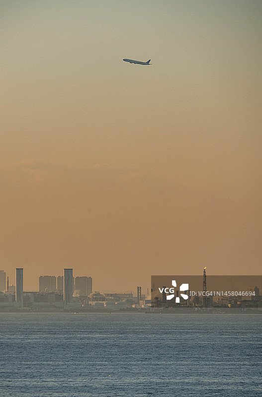 飞机飞过日本川崎市的工厂区图片素材