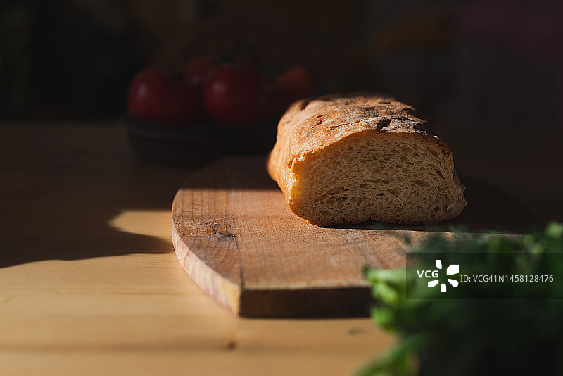 厨房里阳光下木板上的切片软质新鲜面包图片素材