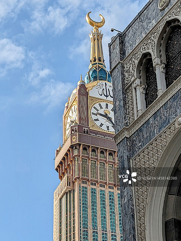 沙特阿拉伯麦加禁寺卡巴圣殿附近的钟表/麦加塔，朝圣者为朝觐和副朝在卡巴进行塔瓦夫 | 人们穿着戒律服朝觐和副朝的运动 | 最高建筑图片素材